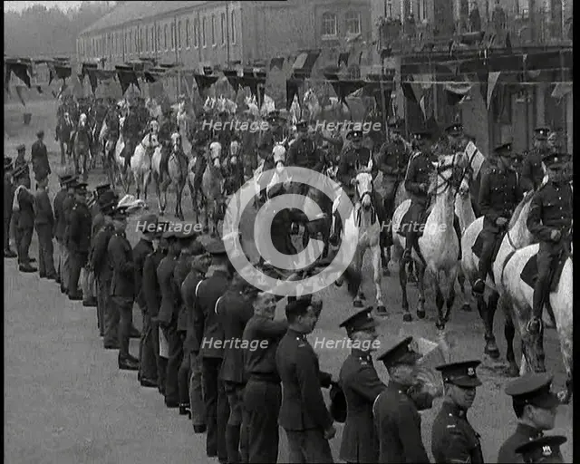 Military Parade of Mounted British Soldiers Riding Down a Street Decorated With Bunting, 1937. Creator: British Pathe Ltd.