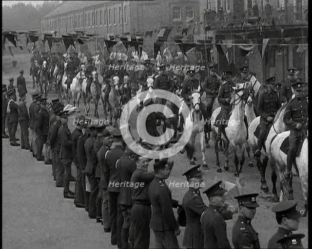 Military Parade of Mounted British Soldiers Riding Down a Street Decorated With Bunting, 1937. Creator: British Pathe Ltd.