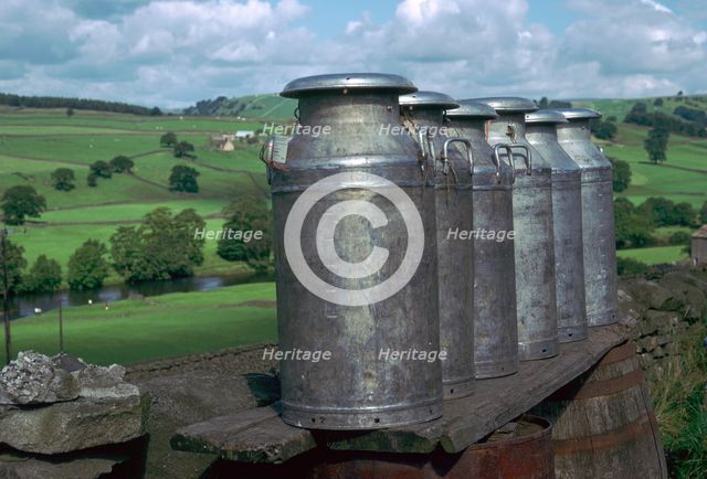 Milk cans at farm gateway.