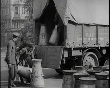 Milk Churns Being Loaded Onto a Lorry by Male Soldiers, 1926. Creator: British Pathe Ltd