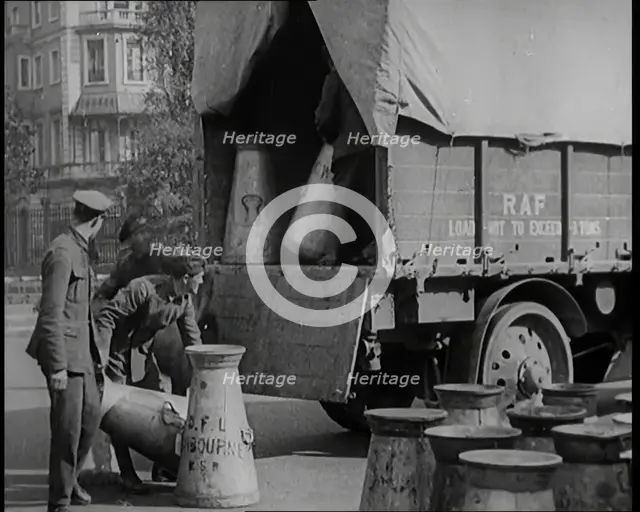 Milk Churns Being Loaded Onto a Lorry by Male Soldiers, 1926. Creator: British Pathe Ltd.
