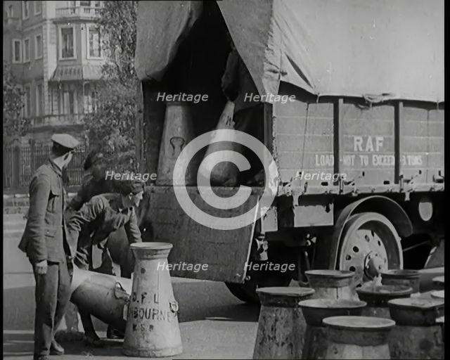 Milk Churns Being Loaded Onto a Lorry by Male Soldiers, 1926. Creator: British Pathe Ltd.