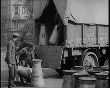 Milk Churns Being Loaded Onto a Lorry by Male Soldiers, 1926. Creator: British Pathe Ltd