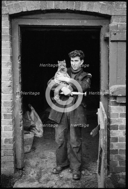 Miller holding a cat, Henley Mill, Henley, Bitterley, Shropshire, 1960-1968. Creator: Rex Wailes.
