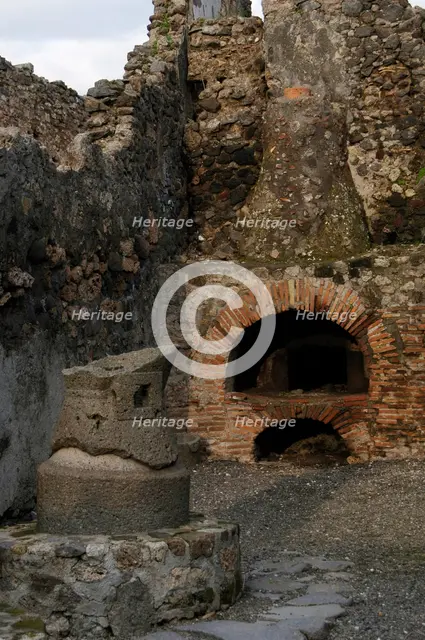 Millstone and oven in the pistrinum, (bakery), Pompeii, Italy, 2009.  Creator: LTL.