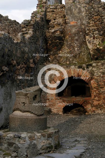 Millstone and oven in the pistrinum, (bakery), Pompeii, Italy, 2009.  Creator: LTL.