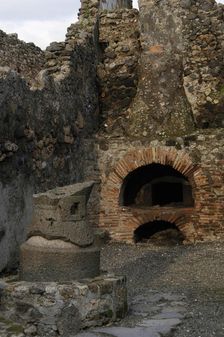 Millstone and oven in the pistrinum, (bakery), Pompeii, Italy, 2009. Creator: LTL