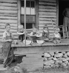 Millworker's children eating watermelon on porch of rented house, Person County, N Carolina, 1939. Creator: Dorothea Lange
