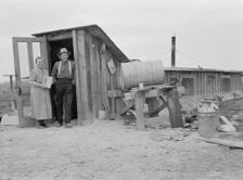 Mr. and Mrs. Wardlow at entrance to their dugout basement home, Dead Ox Flat, Oregon, 1939 Creator: Dorothea Lange