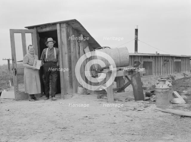Mr. and Mrs. Wardlow at entrance to their dugout basement home, Dead Ox Flat, Oregon, 1939 Creator: Dorothea Lange.
