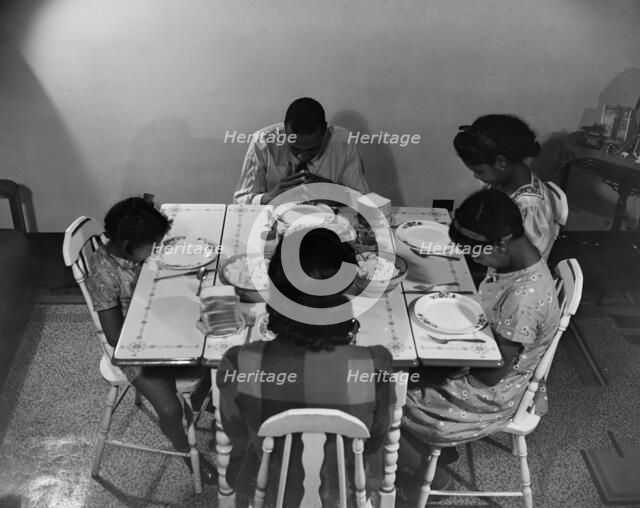 Mr. Branch, resident of the James Creek dwellings, saying grace, Washington, D.C., 1942. Creator: Gordon Parks.