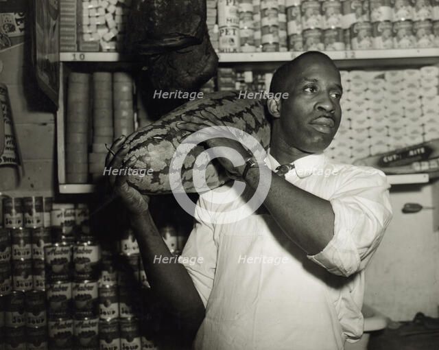 Mr. J. Benjamin, owner of the grocery store patronized by Mrs. Ella Watson..., Washington, DC, 1942. Creator: Gordon Parks.