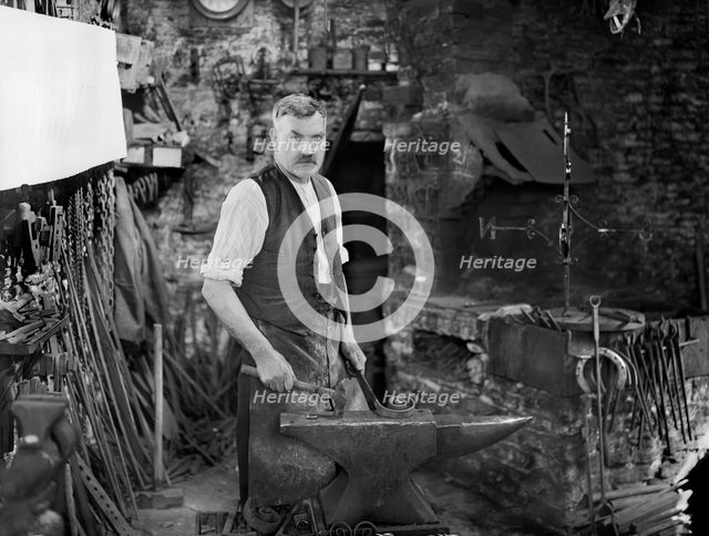 Mr Jefferies at work in the forge, Southrop, Cotswolds, Gloucestershire, 1938. Creator: Sydney Alfred Pitcher.