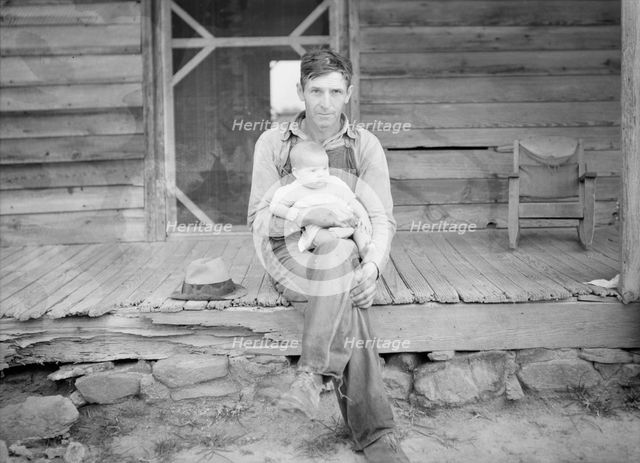 Mr. Whitfield, tobacco sharecropper, with baby on front porch, North Carolina, Person County, 1939. Creator: Dorothea Lange.