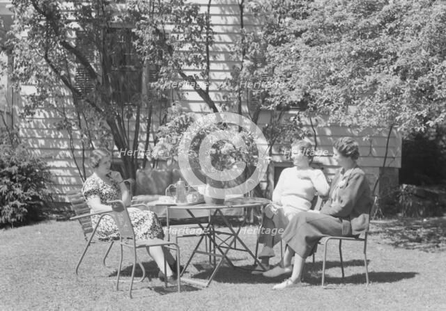 Mrs. Mary Benson and two identified women seated outdoors at a table, between 1933 and 1942. Creator: Arnold Genthe.