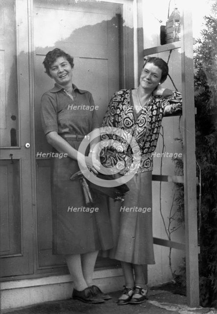 Mrs. Mary Benson and Alice DeLamar, standing by the door of a house, 1933. Creator: Arnold Genthe.