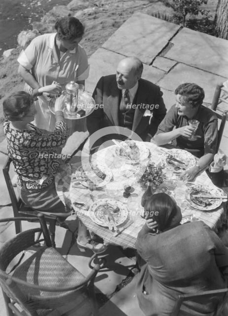 Mrs. Mary Benson and other people seated outdoors, 1933. Creator: Arnold Genthe.
