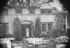 Mrs. Mary Benson standing at the entrance to her house, between 1933 and 1942. Creator: Arnold Genthe