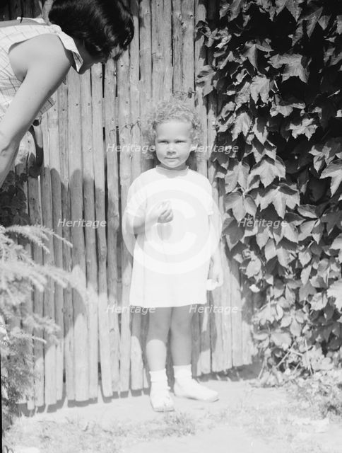 Mrs. Carl Muschenheim and daughter, standing outdoors, 1933 Aug. Creator: Arnold Genthe.
