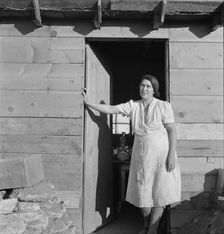 Mrs. Dougherty in doorway of basement house, Warm Springs, Malheur County, Oregon, 1939. Creator: Dorothea Lange