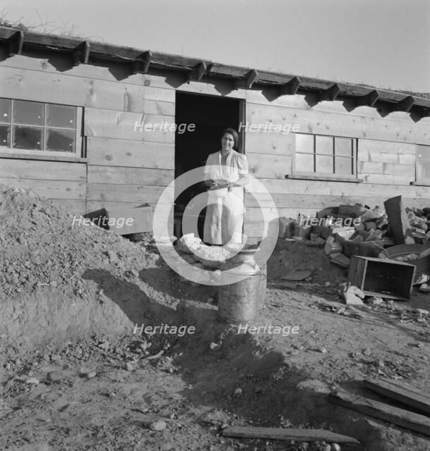 Mrs. Dougherty in doorway of basement house, Warm Springs, Malheur County, Oregon, 1939. Creator: Dorothea Lange.