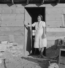 Mrs. Dougherty in doorway of basement house, Warm Springs, Malheur County, Oregon, 1939. Creator: Dorothea Lange