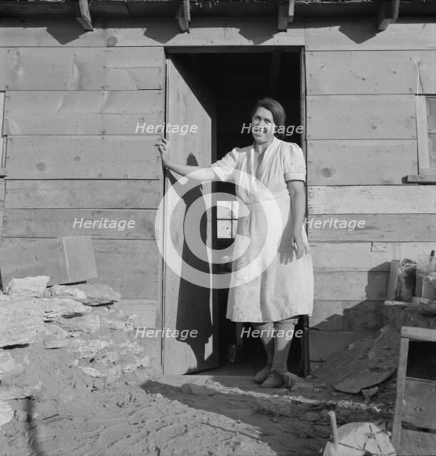 Mrs. Dougherty in doorway of basement house, Warm Springs, Malheur County, Oregon, 1939. Creator: Dorothea Lange.