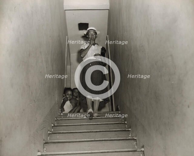 Mrs. Ella Watson, a government charwoman, leaves for work at 4:30 p.m., Washington, D.C., 1942. Creator: Gordon Parks.