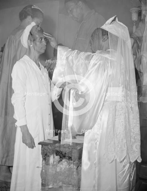 Mrs. Ella Watson, a government charwoman, receiving annointment..., Washington, D.C., 1942. Creator: Gordon Parks.