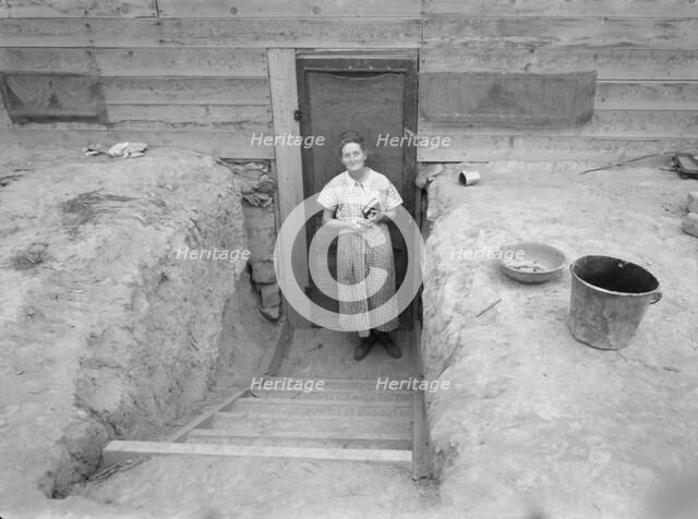 Mrs. Free in doorway of her basement dugout home, Dead Ox Flat, Oregon, 1939. Creator: Dorothea Lange.