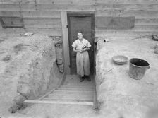 Mrs. Free in doorway of her basement dugout home, Dead Ox Flat, Oregon, 1939. Creator: Dorothea Lange
