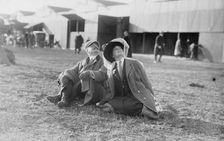 Mrs. Payne Whitney with unidentified gentleman seated on flying field of aviation meet, 1910. Creator: Bain News Service