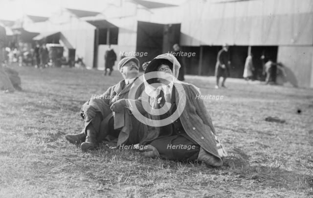 Mrs. Payne Whitney with unidentified gentleman seated on flying field of aviation meet, 1910. Creator: Bain News Service.
