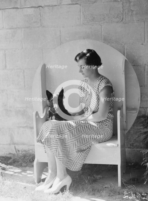 Mrs. Walter Fletcher with dog, seated outdoors, between 1933 and 1942. Creator: Arnold Genthe.