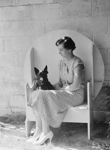 Mrs. Walter Fletcher with dog, seated outdoors, between 1933 and 1942. Creator: Arnold Genthe