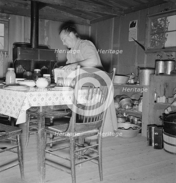 Mrs. Wardlow bakes her own bread in her dugout house, Dead Ox Flat, Malheur County, Oregon, 1939. Creator: Dorothea Lange.