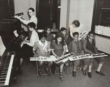 Music classes, keyboards and piano, 1938. Creator: Aubrey Pollard