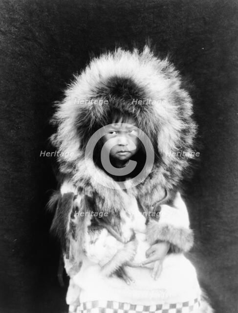 Noatak child, three-quarter length portrait, seated, facing front, c1929. Creator: Edward Sheriff Curtis.