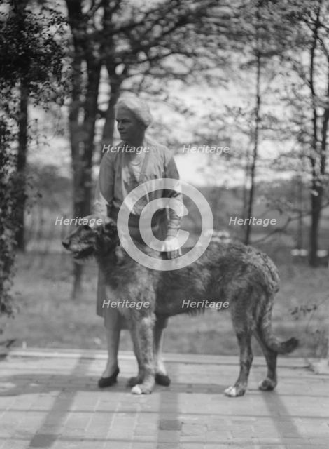 Noland, Charlotte, Miss, with dog, standing outdoors, 1931 May 8. Creator: Arnold Genthe.