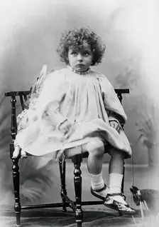 Nora Schuster aged 3, seated, facing forwards, c1895. Creator: Mrs Fred Wilkinson