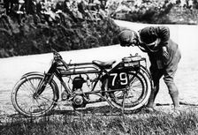 Norman Black repairing a punture on his Norton bike, 1920