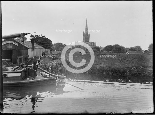 Norwich Cathedral from Pull's Ferry, with men on a boat in the foreground, Norwich, Norfolk, 1920-38 Creator: George R Long.