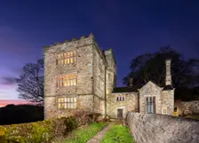 North Lees Hall from the south-east with the windows illuminated, Hathersage, Derbyshire, 2025. Creator: Alun Bull