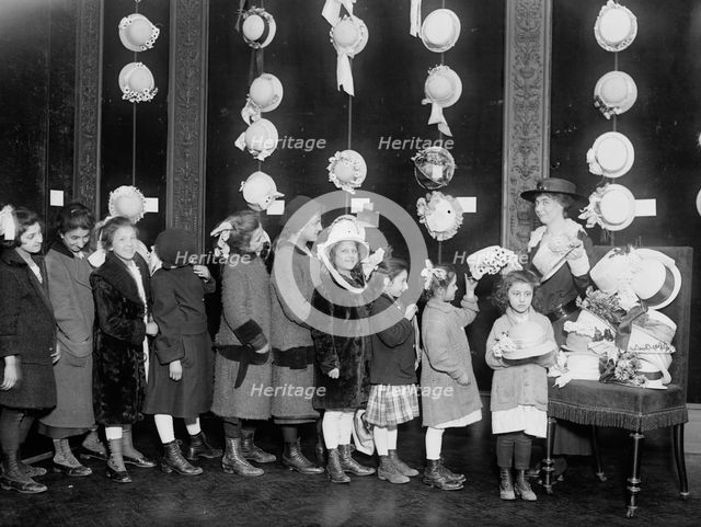 Natalie Stewart Distributing hats to poor children, between c1915 and c1920. Creator: Bain News Service.