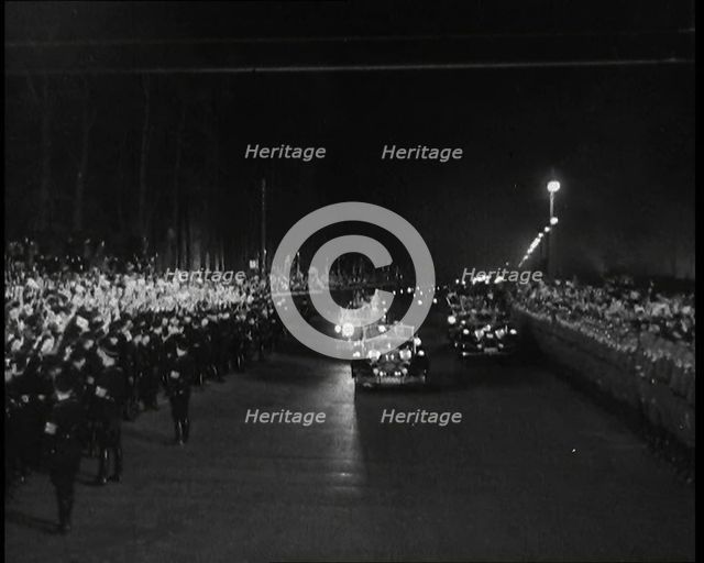Nazi Party Staff Cars Driving Down a Wide Road in Berlin Edged With...Soldiers..., 1937 Creator: British Pathe Ltd.