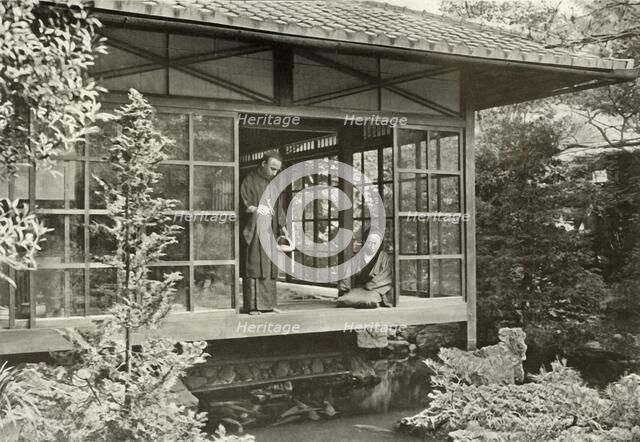 'Namikawa San Feeding His Carp', 1910. Creator: Herbert Ponting.
