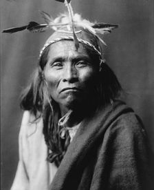 Ndee Sangochonh, Apache Indian, half-length portrait, facing front, c1906. Creator: Edward Sheriff Curtis