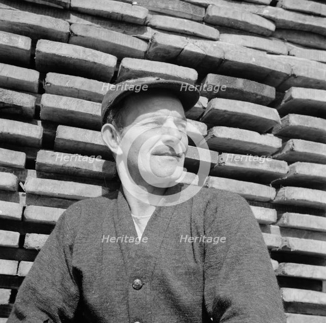 New England fisherman resting at the New York docks after unloading his cargo of fish, 1943. Creator: Gordon Parks.