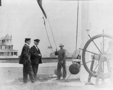 New York Yacht Club, Oyster Bay, L.I., 1905: 2 men watching sailor hoist flag, 1905. Creator: Frances Benjamin Johnston