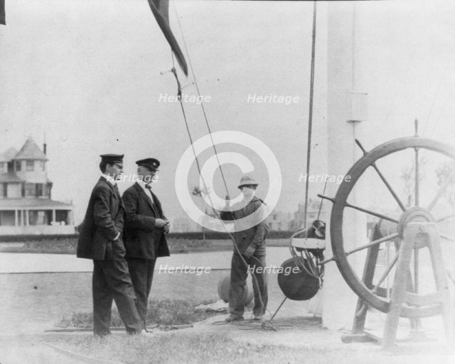 New York Yacht Club, Oyster Bay, L.I., 1905: 2 men watching sailor hoist flag, 1905. Creator: Frances Benjamin Johnston.